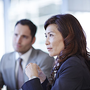 Asian-American woman sitting attentively at a business meeting